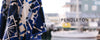 Close-up of a blue and white Pendleton blanket with a geometric pattern; background shows a blurred harborside scene with boats and buildings. Text on the right reads