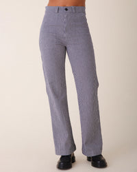 A person wearing Prairie Underground’s Long Smithy Pant in Oyster with a straight-leg fit and black shoes stands against a plain light background.