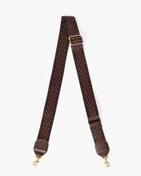 The Clare V. Adjustable Crossbody Strap - Checkered in Chocolate features a red and black checkerboard pattern, brown leather ends, gold-tone swivel hooks, and an adjustable gold buckle, shown on a white background.