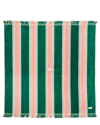 The Beach Blanket - Bistro Green Stripe by Business & Pleasure Co features vertical green and pink stripes, white fringe on the short ends, a center hole, corner label, and is crafted from 100% cotton for a soft, family-friendly feel.