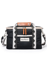 The Premium Cooler Bag - Rivie Black by Business & Pleasure Co is a rectangular, black insulated cooler bag with a vintage look, white zigzag straps, brown leather accent, and a zippered top. Eco-friendly.