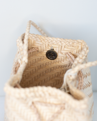A close-up view of the inside of the Dragon Diffusion Pom Pom Double Jump in Peachy Natural, showing a single metal snap button closure.