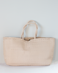 The Shopper Bag - Max in Peachy Natural by Dragon Diffusion, featuring two braided handles, is displayed against a plain light background.