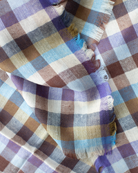 A close-up of the Épice Plaid Wool Bandana in Blue showcases its multicolored checkered pattern with frayed edges—ideal as a stylish accessory or cozy scarf.