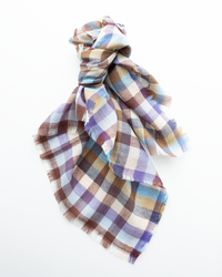 The Épice Plaid Wool Bandana in Blue features a loosely knotted design with frayed edges and a checked pattern in brown, blue, purple, and beige, shown against a white background.