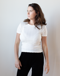 A woman in the Enati S/S Crew Neck Top in Ecru by Velvet by Graham & Spencer.