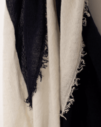 A close-up of the Grisal Love Duo Mini in Navy X Milk, featuring frayed black and white fabric with rough texture and uneven edges, hanging side by side against a light background.