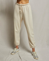 Model wears the Johnny French Terry Easy Sweatpant in Sugar by perfectwhitetee with light gray sneakers, standing against a plain light background. Only the lower half of the body is visible.