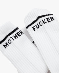 MF Baby Steps in White by Mother are white ribbed tube socks featuring black text—one sock says MOTHER and the other FUCKER near the cuff—for a bold, vintage-inspired style.