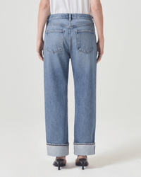 A person is shown from the back against a plain light background, wearing AGOLDE's Fran Low Slung Straight in Invention jeans and black heeled sandals.