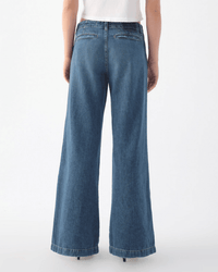 A person wearing the Edith Wide Leg Trouser in Romance by AMO and a white top stands facing away from the camera against a plain white background.