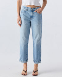 Person wearing AMO’s Valentina Relaxed Straight in Heartfelt, featuring a high-waisted, relaxed straight-leg fit with rolled cuffs; styled with a white cropped tank and brown sandals. Face is not visible; background is plain and light.