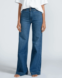 A person stands barefoot in the ASKK NY Brighton Wide Leg in Mercury, crafted from Japanese stretch denim, paired with a white short-sleeve t-shirt, arms relaxed at their sides against a plain light background.