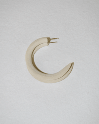 The B&L C Hoop in Small in Chanel Ivory is a single crescent-shaped, beige mango wood earring with a matte finish, crafted from sustainably sourced materials and shown on a textured, light gray surface.