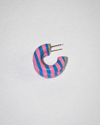 The B&L C Hoop in Mini in Places You'll Go is a chunky mango wood earring with pink and blue diagonal stripes, evoking playful Dr. Seuss vibes, shown on a plain white background.