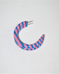 The B&L C Hoop in Small in Places You'll Go is a crescent-shaped mango wood earring with alternating pink and blue stripes, sustainably handmade by Filipino artisans. It features two metal posts and is shown on a plain white background.