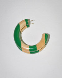 The B&L Large Chunk Hoop in Tommy is a chunky, crescent-shaped mango wood earring with alternating green and natural stripes, featuring two gold posts for fastening, shown on a light textured surface.