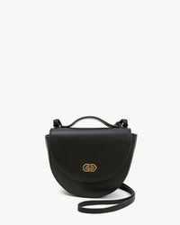 The Clare V. Elodie in Black Veg is a small Italian Vachetta bag with a curved flap, gold-tone clasp, and thin crossbody strap, shown against a plain white background.