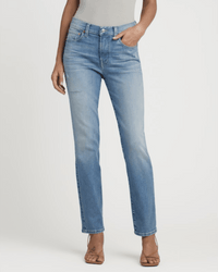Someone stands against a plain white background with one hand in their pocket, wearing Edwin’s Bree in Reverie jeans and strappy heeled sandals.
