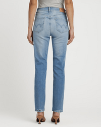 A person wearing Edwin's Bree in Reverie light blue ankle-length jeans with curved-stitched back pockets and high-heeled sandals, shown from behind against a plain white background.