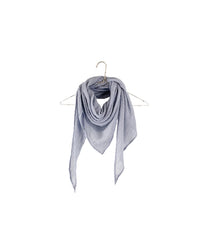 The It is well LA Gauze Triangle Scarf in Heather Blue, made of 100% cotton, hangs loosely from a wire hanger against a plain white background with its ends draping down.