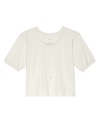 The Scoop Henley in Natural by the Great is a plain white, short-sleeve crop top with a round neckline and three-button placket, crafted from 100% cotton for a soft, vintage-inspired feel.