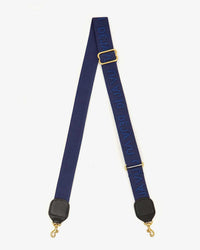 The Clare V. Deja Vu Adj Crossbody Strap in Navy Tonal features "DÉJÀ VU" woven in blue, gold-tone hooks, and black leather accents—perfect for upgrading your bag with a chic navy strap.
