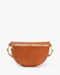 The Grande Fanny in Cuoio Perf by Clare V. is a tan, half-moon-shaped crossbody fanny pack in perforated leather with a gold zipper and matching adjustable strap, shown against a plain white background.