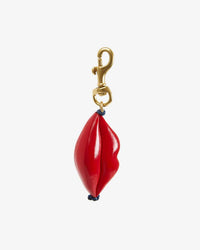 The Clare V. Lips FOB keychain features a gold ring with a red leather lips charm, attached by a small blue cord, displayed on a plain white background.
