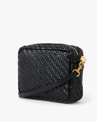 The Clare V. Midi Sac in Black Woven Zig-Zag is a small crossbody bag with a gold zipper and clasp, plus a long adjustable strap, displayed against a plain white background.