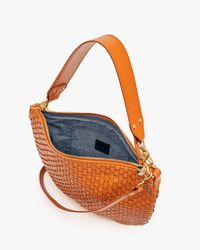 The Clare V. Moyen Messenger in Natural Woven Checker features gold hardware, a wide shoulder strap, and a detachable crossbody strap. This open tan bag has a gray fabric lining with a small pocket inside.