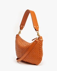 The Clare V. Moyen Messenger in Natural Woven Checker, featuring gold hardware, a wide adjustable strap, and a rounded silhouette, is displayed against a plain white background.