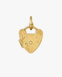 The Clare V. Padlock Locket in Vintage Gold features a heart-shaped design with engraved symbols and a circular clasp, making it an eye-catching addition to any charm necklace. Shown against a plain white background.