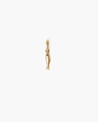 The Clare V. Sardine Charm in Vintage Gold features a small, fish-shaped design hanging vertically—perfect for adding to your favorite charm bracelet.