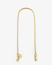 The Clare V. Snake Chain Shoulder Strap in Vintage Gold features lobster clasps at both ends and a small round tag, displayed flat on a white background—an elegant accessory for Clare V. bags.