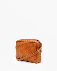 The Clare V. Woven Checker Midi Sac in Natural is a small, rectangular crossbody bag with woven tan leather, gold hardware, and a matching adjustable strap, shown against a plain white background.