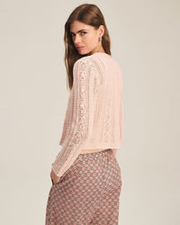 A woman with long brown hair models the Daisy Long Sleeve Crew Cardi in Blush by Velvet by Graham & Spencer, standing against a plain background and looking over her shoulder at the camera.