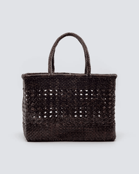 The Dragon Diffusion Cannage Max in Dark Brown is a rectangular handwoven leather tote with two braided handles, featuring an open-weave middle, tightly woven base and top, styled on a plain light gray background.