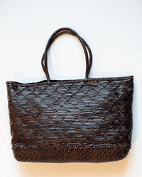 A dark brown Dragon Diffusion EW Corso Bag with two handles, featuring a textured crisscross diamond pattern on the body and plain woven borders at the top and bottom, set against a white background.