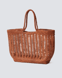 The Dragon Diffusion Window Basket in Tan is a large hand-woven bag with two handles, an open airy design, and a sturdy flat base, shown against a light gray background.