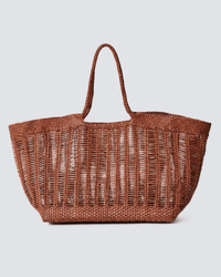 The Dragon Diffusion Window Shopper in Tan is a large tote with an open, airy design and braided handles, shown against a plain light gray background.