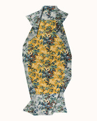 The Épice Fleur 2 Scarf in Amarillo is a floral wool scarf with an abstract shape, featuring a central yellow panel and blue and white floral borders, shown flat on a white background.