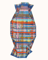 The Épice Painterly Plaid Scarf in Sunset features overlapping abstract stripes in blue, red, purple, yellow, and orange with angular folded edges, set against a plain background.