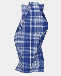The Épice Tweed Check Scarf in Blue, featuring a blue and white plaid pattern with a woven texture, is displayed laid flat against a white background, arranged in a loose, twisted shape.
