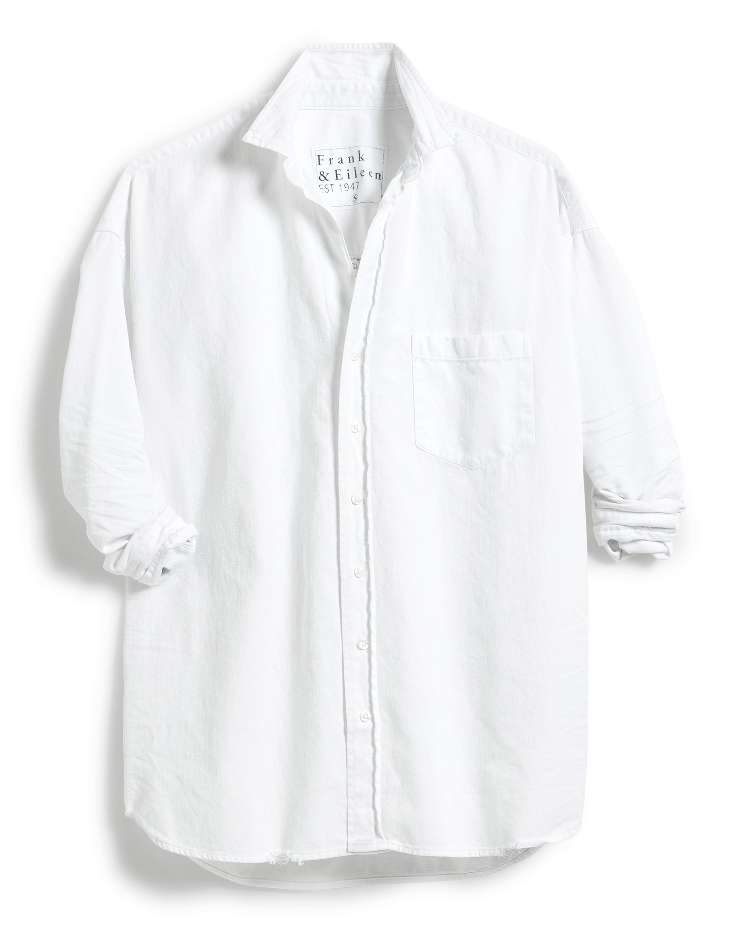 The Shirley Oversized Button-Up Shirt in White Distressed Famous Denim by Frank & Eileen features a long-sleeve collared design, rolled-up sleeves, an oversized fit, and a single chest pocket.