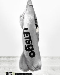 The Free City FCLetsGo Bleachout OG Sweatpant in Heather Bleachout features unique hand-bleached details, bold black OSLO and XIII lettering, and "art commerce" partially cut off along the bottom edge.