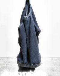The Free City Lucky Rabbits Sweatshirt in Moonshroom Blue, a dark blue French terry hoodie, hangs on a hook against a plain white background with "lucky rabbits" faintly visible at the bottom.