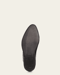 Bottom view of the FRYE Billy Short in Black: a single black leather ankle boot with a pointed toe, smooth leather sole, textured heel section, and HME stamped near the arch. Shown against an off-white background.