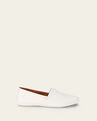 The FRYE Melanie Slip On in White showcases a vintage leather upper with minimal stitching and a flat sole, shown in a side profile against a beige background.
