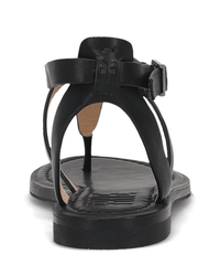 The FRYE Taylor Sandal in Black, shown from the back, features an adjustable ankle strap with buckle, a T-strap design, and a flat sole.